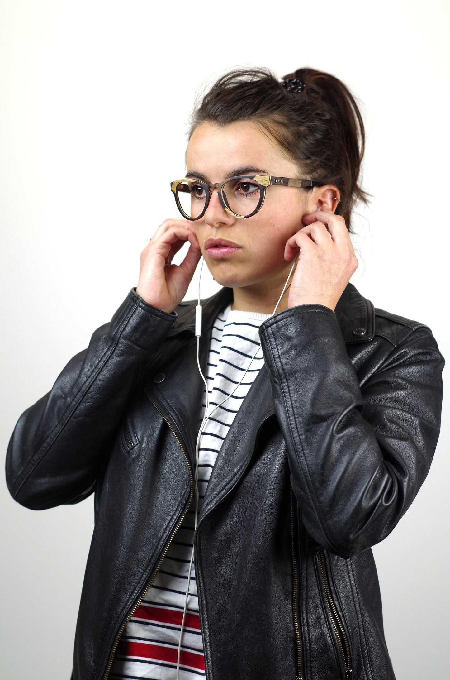 personne mettant ses écouteurs et portant des lunettes  en bois psir la bordelaise