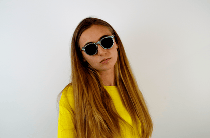 femme pull jaune portant des lunettes de soleil originales en bois